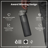 A dark-grey water bottle is being held; its features—a hide-away handle, hygiene cover, and wide mouth—are highlighted against a dark background. 